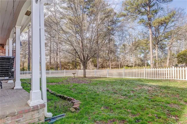 a view of a house with a yard and large trees