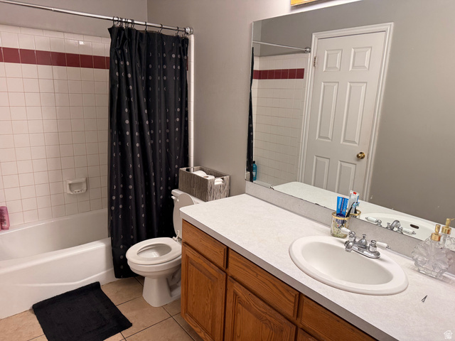 183 East 820 South Centerville, UT 84014 - Photo 10 of 14 Bathroom featuring a white bathtub and shower surround with a red accent tile band, white vanity with an integrated sink, wood-finish cabinetry, and a wall-mounted mirror