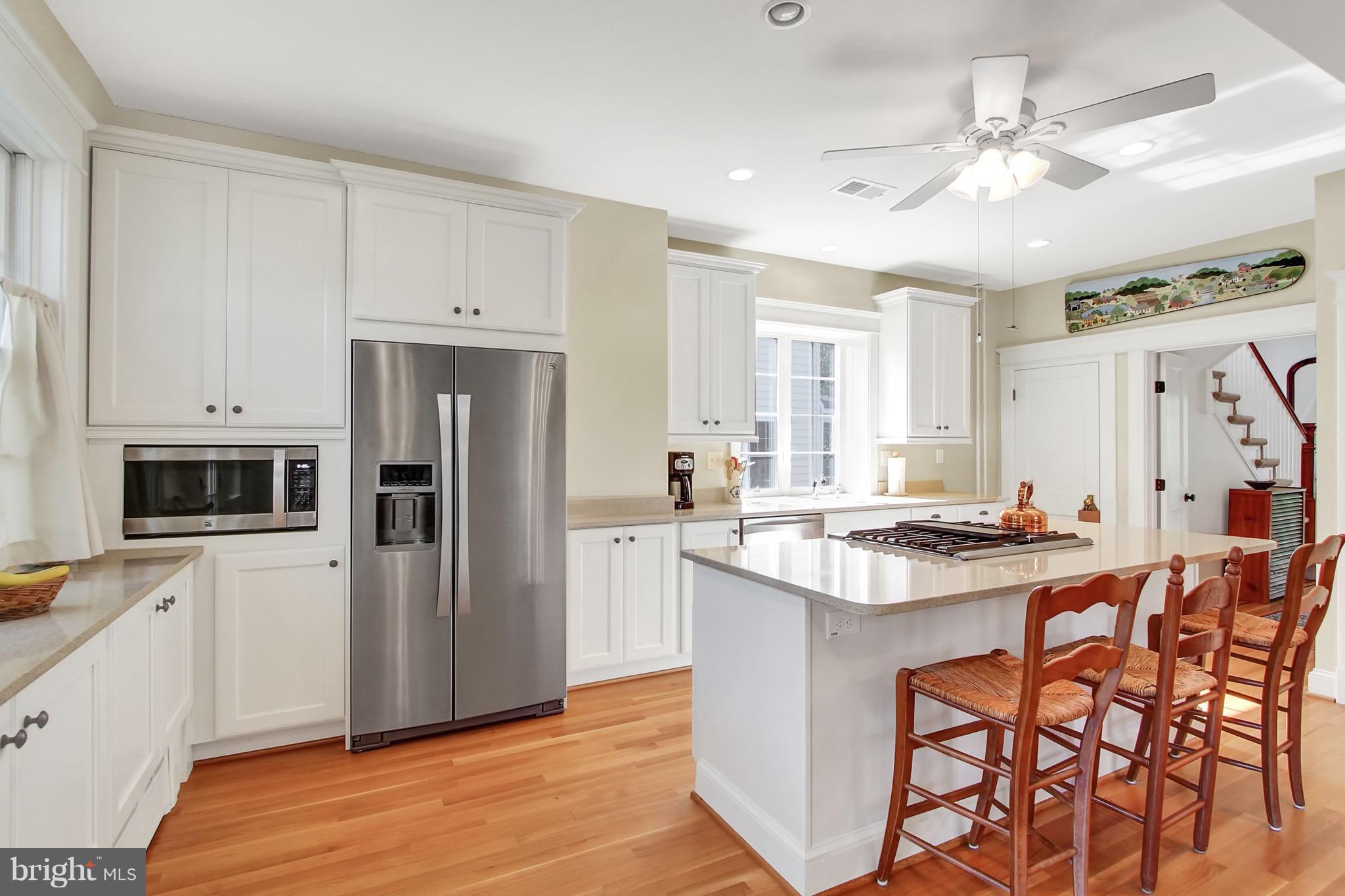 600 Murdock Road Baltimore, MD 21212 - Photo 12 of 30 a kitchen with stainless steel appliances a stove a sink a refrigerator and white cabinets with wooden floor