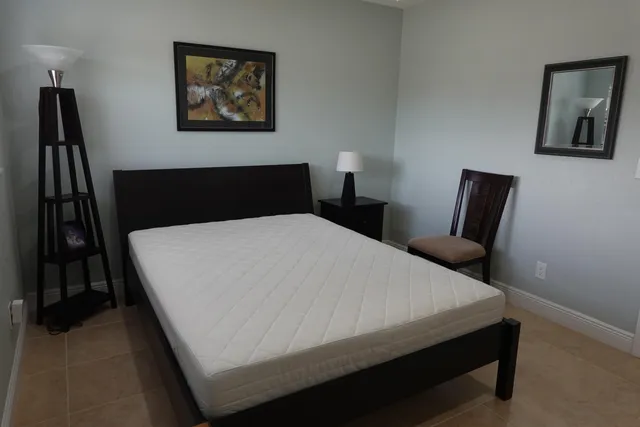 a bed sitting in a bedroom next to a lamp