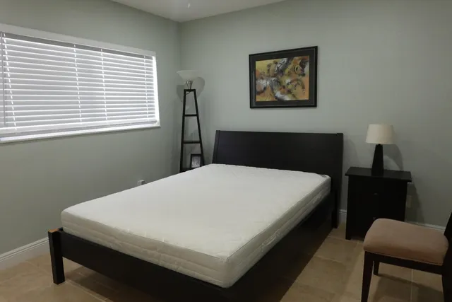 a bed sitting in a bedroom next to a window