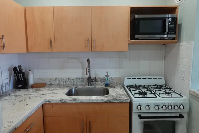 a kitchen with granite countertop a stove and a sink