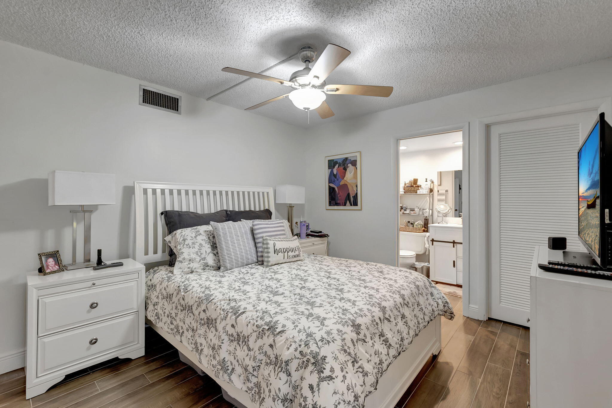 66 Capri B Delray Beach, FL 33484 - Photo 21 of 62 a bedroom with a large bed and a chandelier