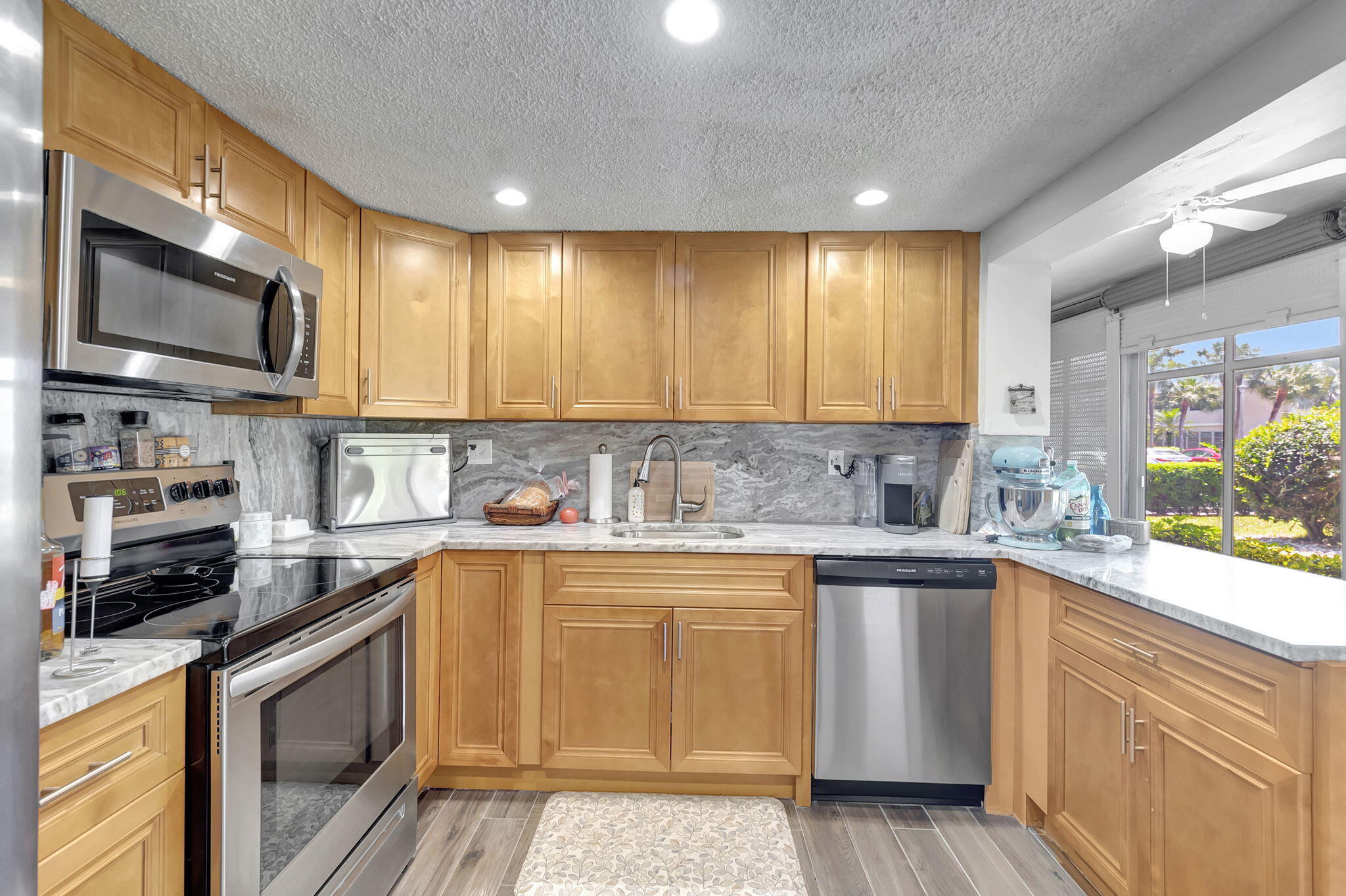 66 Capri B Delray Beach, FL 33484 - Photo 7 of 62 a kitchen with stainless steel appliances granite countertop a stove a sink and a microwave