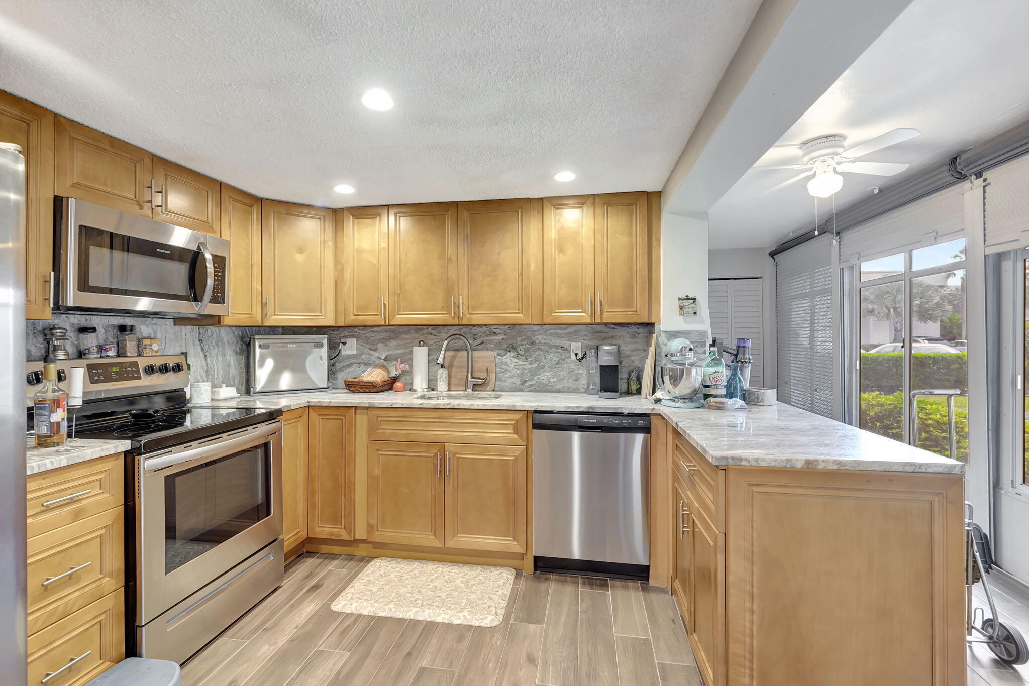 66 Capri B Delray Beach, FL 33484 - Photo 8 of 62 a kitchen with stainless steel appliances granite countertop wooden cabinets a sink and dishwasher a stove with wooden floor