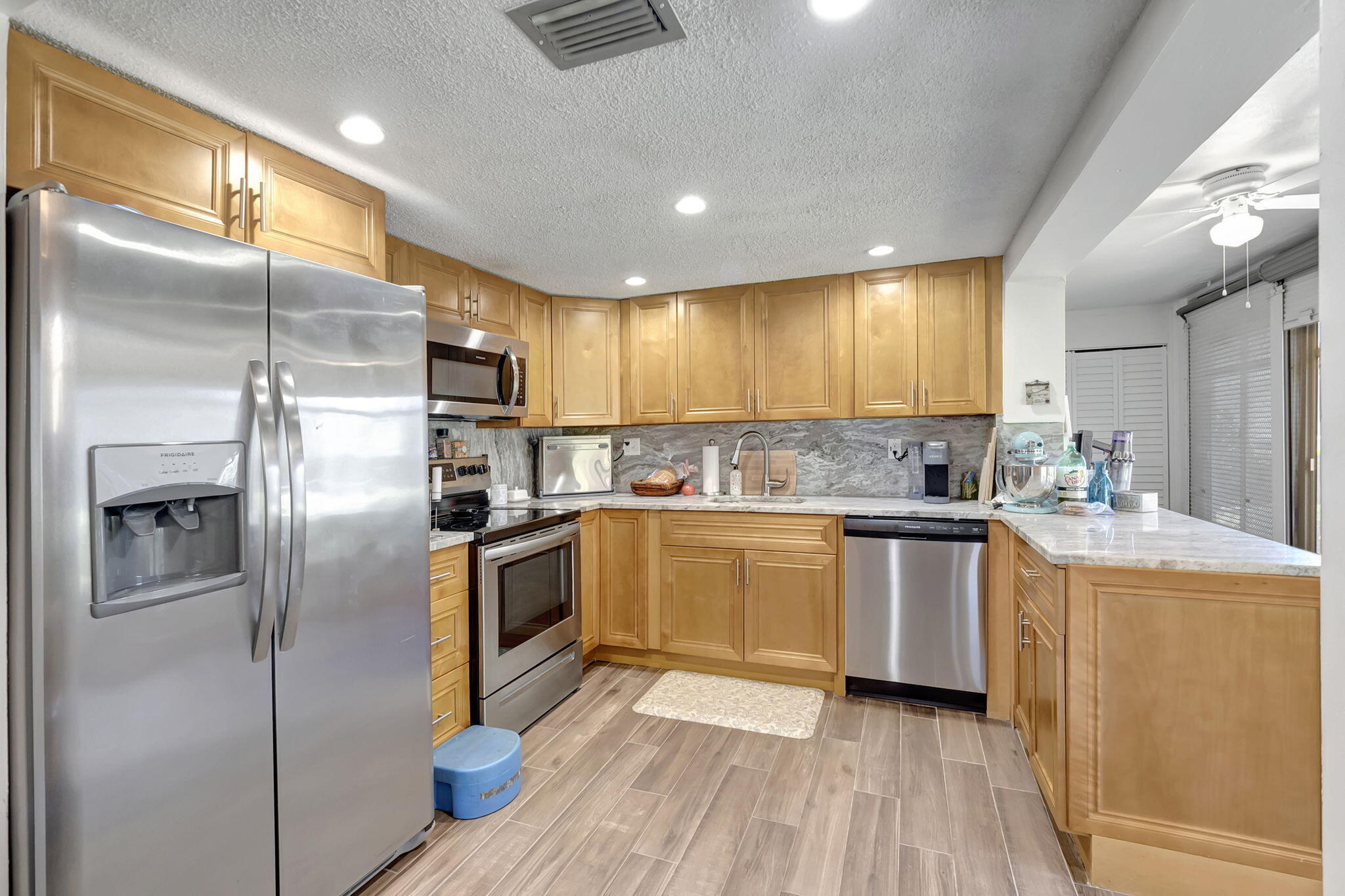66 Capri B Delray Beach, FL 33484 - Photo 9 of 62 a kitchen with granite countertop stainless steel appliances a refrigerator cabinets and wooden floor
