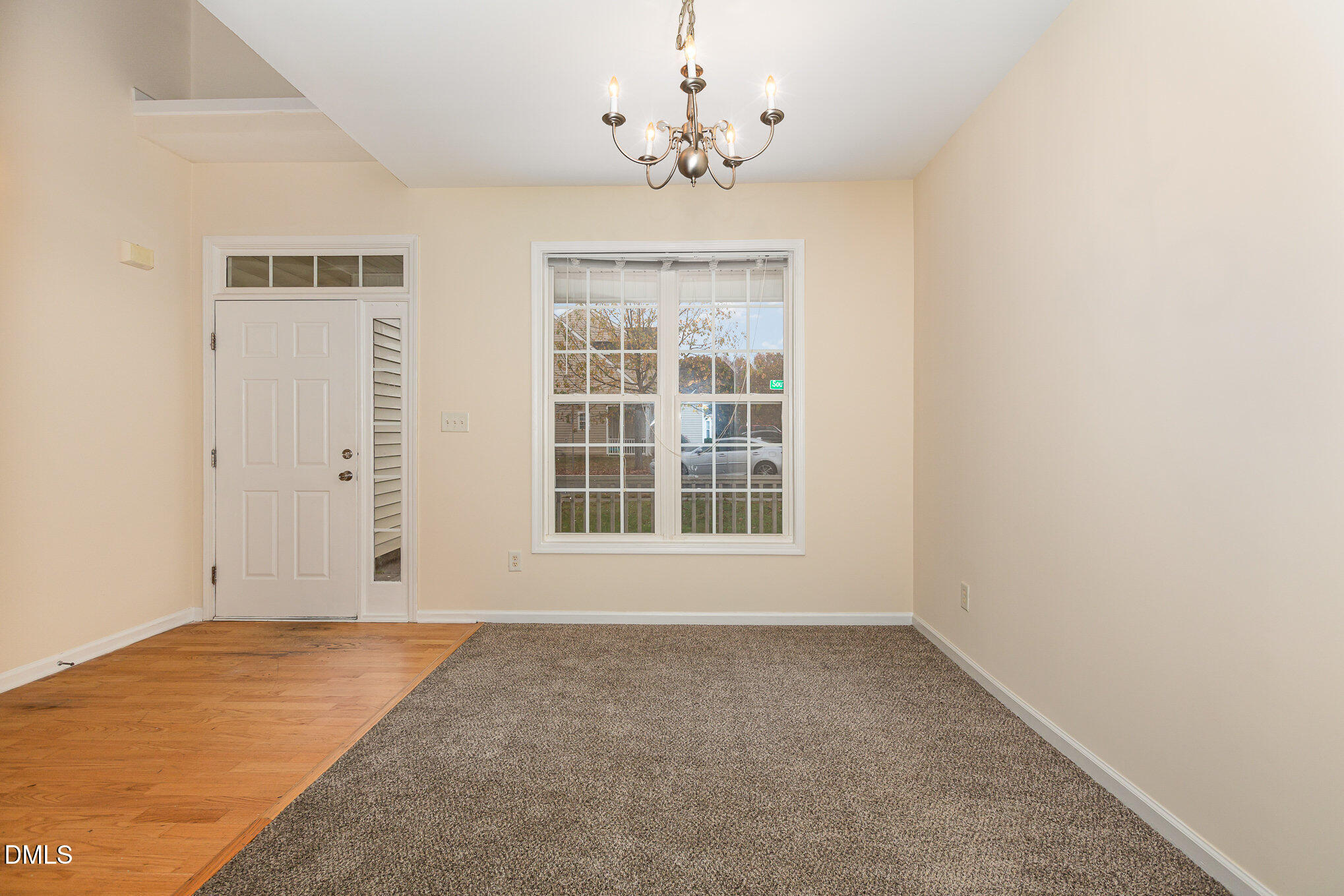 2124 Star Sapphire Drive Raleigh, NC 27610 - Photo 4 of 23 an empty room with a chandelier fan and windows