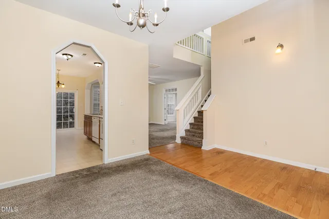 a view of a livingroom with wooden floor and staircase