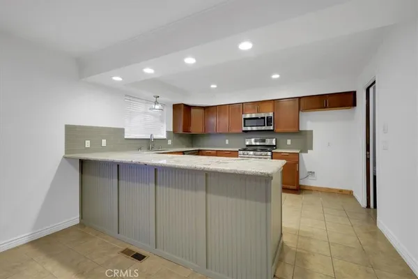 a kitchen with stainless steel appliances granite countertop a stove a sink dishwasher and a refrigerator