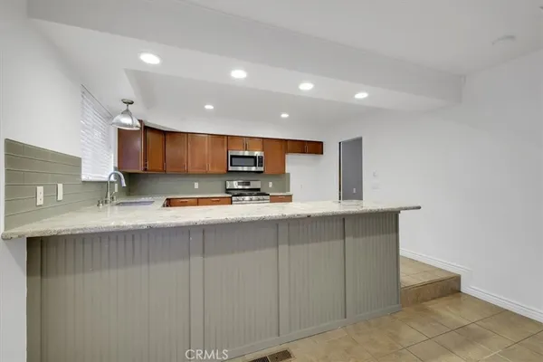 a large kitchen with stainless steel appliances granite countertop a sink and dishwasher