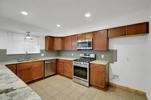 a kitchen with stainless steel appliances granite countertop a sink and stove top oven