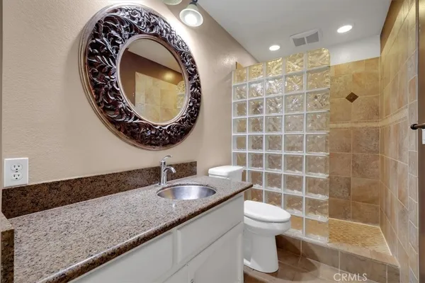 a bathroom with a granite countertop sink and a mirror