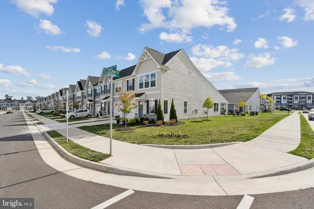 a view of a white house next to a yard