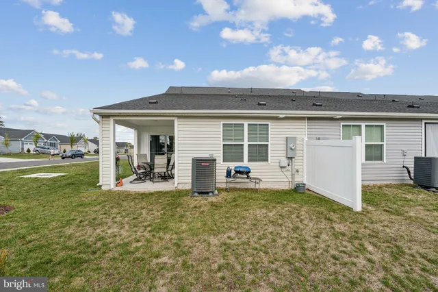 a view of a house with a big yard and large tree