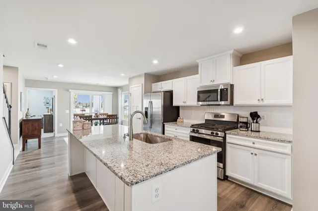 a kitchen with stainless steel appliances granite countertop a sink stove and cabinets