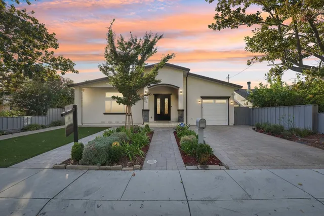 front view of a house with a yard and potted plants