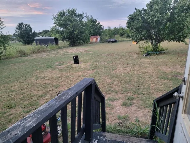 a view of a dry yard with wooden fence
