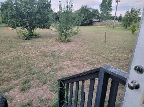 a living room with stainless steel appliances kitchen island granite countertop a refrigerator a stove a sink a microwave a counter space and cabinets