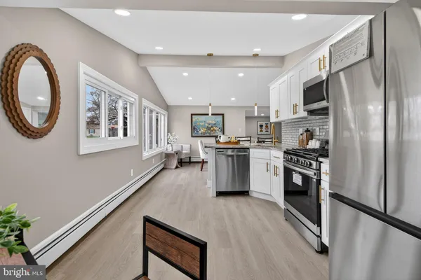 a kitchen with stainless steel appliances granite countertop a refrigerator a stove and a sink