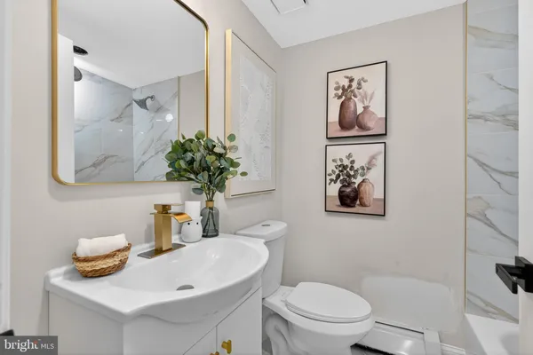 a bathroom with a toilet sink and mirror