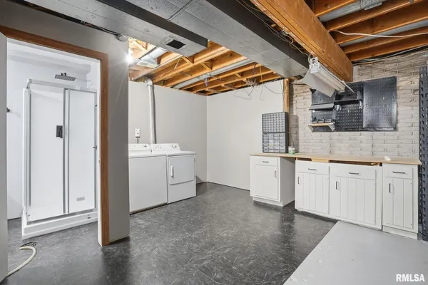 a view of a kitchen with white cabinets and wooden floors