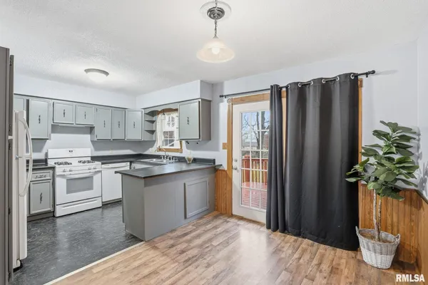 a kitchen with stainless steel appliances granite countertop a refrigerator a stove a sink and white cabinets