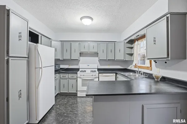 a kitchen with a refrigerator sink and cabinets