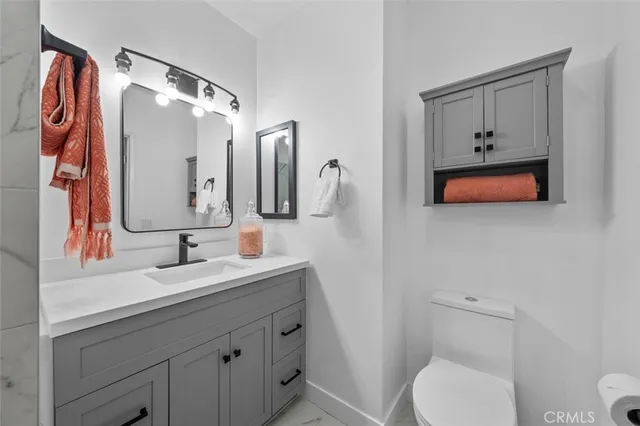 a bathroom with a toilet sink and mirror