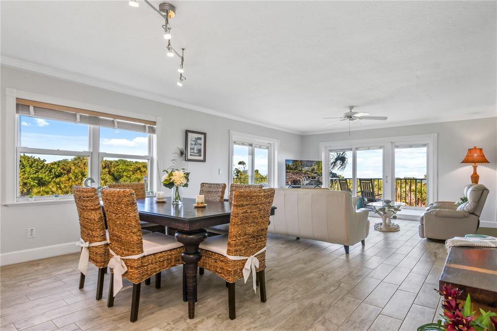 8700 Ridgewood Avenue, Unit 204B Cape Canaveral, FL 32920 - Photo 6 of 10 a dining room with furniture large windows and wooden floor