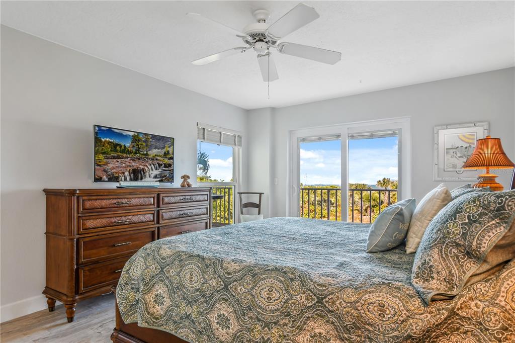 8700 Ridgewood Avenue, Unit 204B Cape Canaveral, FL 32920 - Photo 7 of 10 a bedroom with a bed a dresser and a chandelier