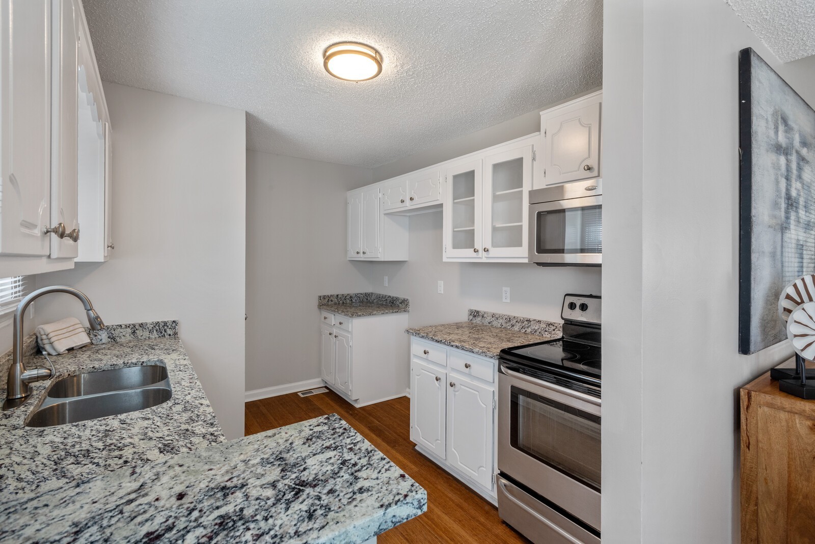1617 Alsdale Road Mount Juliet, TN 37122 - Photo 9 of 34 a kitchen with stainless steel appliances granite countertop a sink stove oven and white cabinets