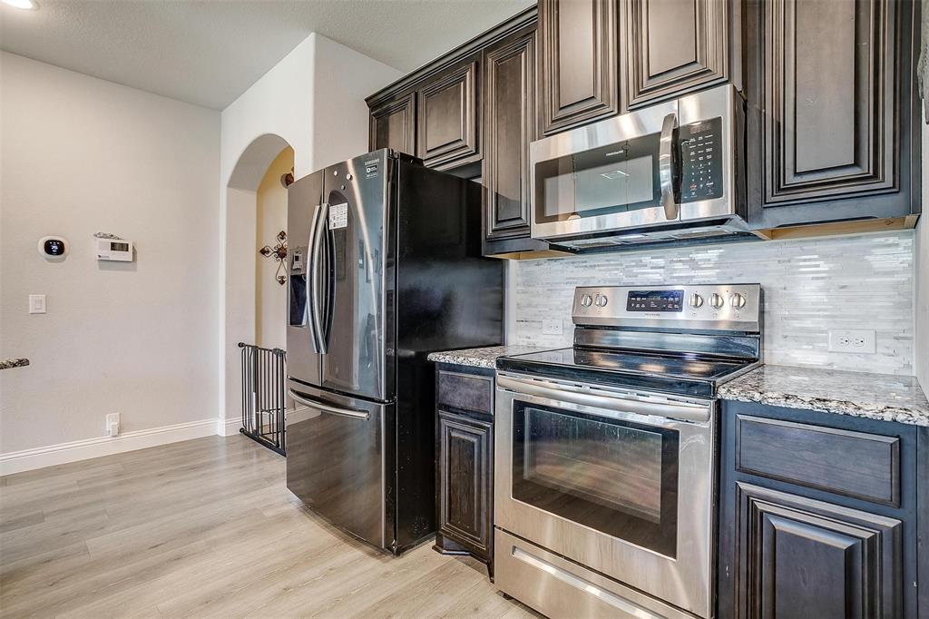 433 Joseph Lane Crowley, TX 76036 - Photo 13 of 40 a kitchen with stainless steel appliances granite countertop a stove microwave and refrigerator