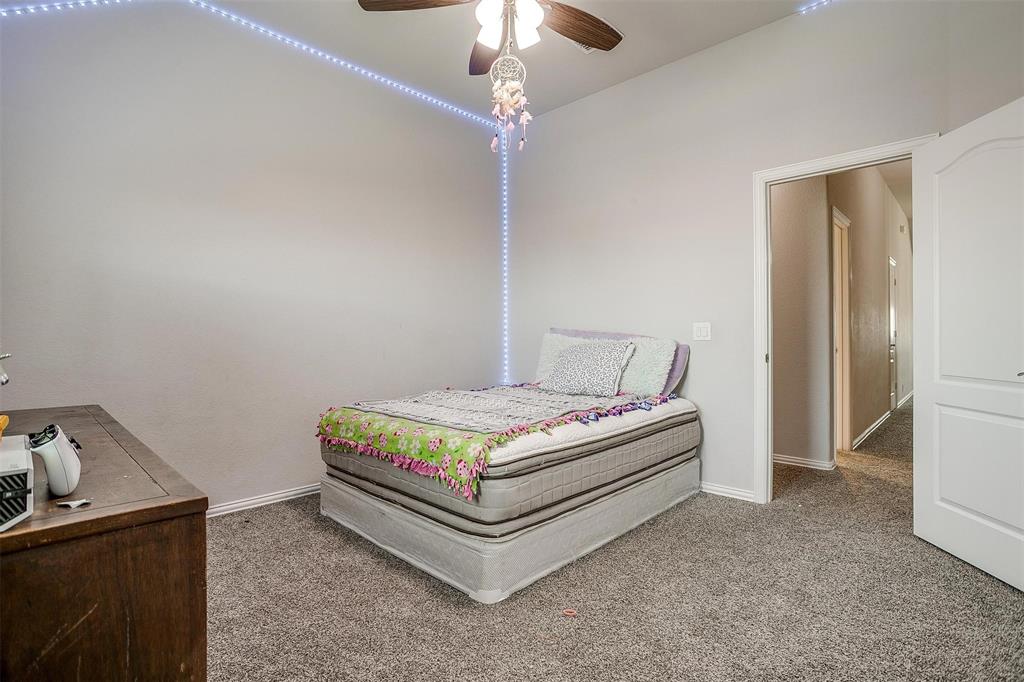 433 Joseph Lane Crowley, TX 76036 - Photo 35 of 40 a bedroom with a bed and a chandelier