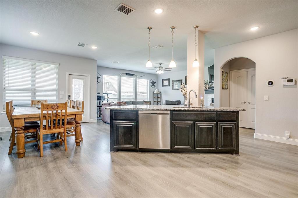 433 Joseph Lane Crowley, TX 76036 - Photo 9 of 40 a kitchen with stainless steel appliances granite countertop a stove a sink a refrigerator and a dining table with wooden floor