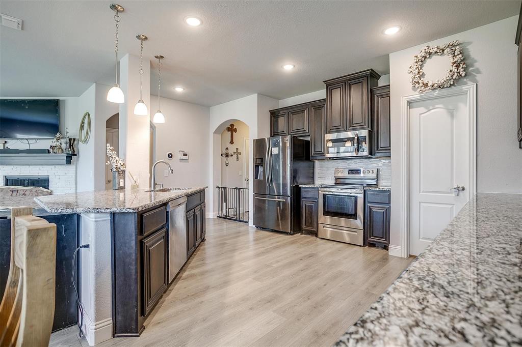 433 Joseph Lane Crowley, TX 76036 - Photo 10 of 40 a kitchen with stainless steel appliances kitchen island granite countertop a refrigerator a stove a sink and a oven