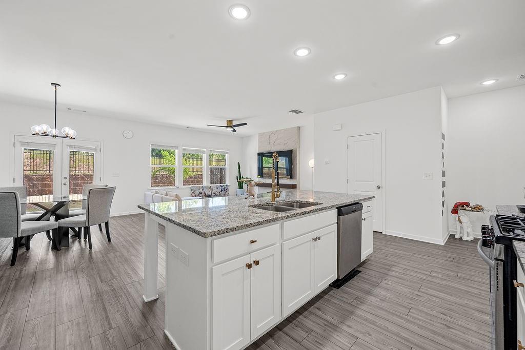922 Edwin Lane Sugar Hill, GA 30518 - Photo 12 of 43 a kitchen with stainless steel appliances granite countertop a kitchen island hardwood floor sink stove dining table and chairs