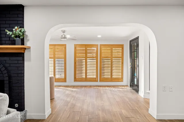 an empty room with a window and a ceiling fan