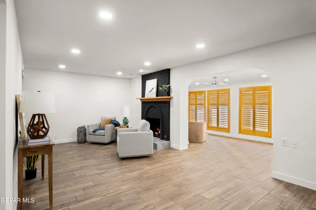 a view of a hallway with wooden floor and a bathroom