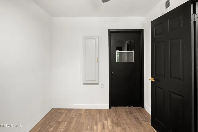 a view of a hallway with wooden floor and closet