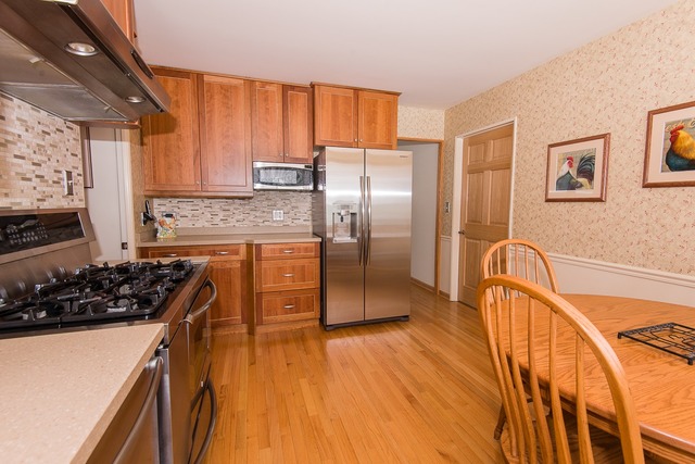 1165 Oxford Road Deerfield, IL 60015 - Photo 5 of 16 a kitchen with stainless steel appliances granite countertop a refrigerator a stove and a wooden floors