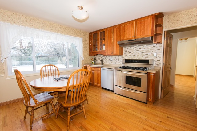 1165 Oxford Road Deerfield, IL 60015 - Photo 6 of 16 a kitchen with stainless steel appliances granite countertop a stove top oven a sink with dining table and chairs