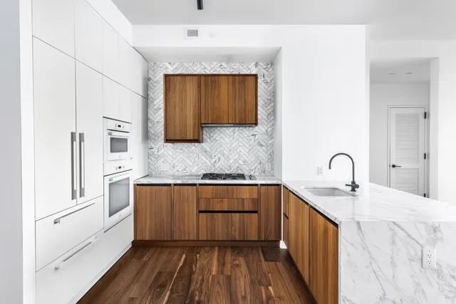 a kitchen with stainless steel appliances granite countertop a sink stove and cabinets