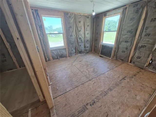 a view of an empty room with a fireplace and a window