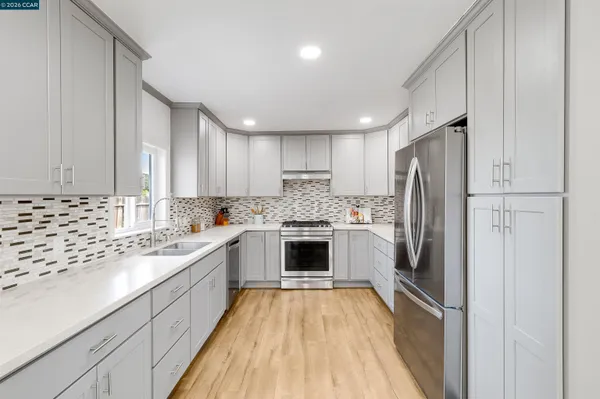 a kitchen with a refrigerator sink and cabinets