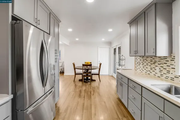 a kitchen with stainless steel appliances granite countertop a refrigerator and a sink