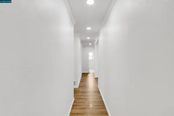 a view of a hallway with wooden floor