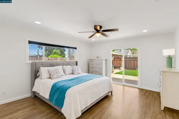 a bedroom with a balcony a bed and a view of kitchen