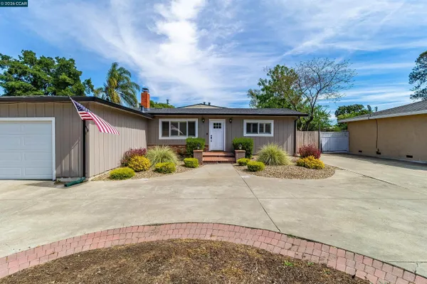 a view of a house with backyard and sitting area
