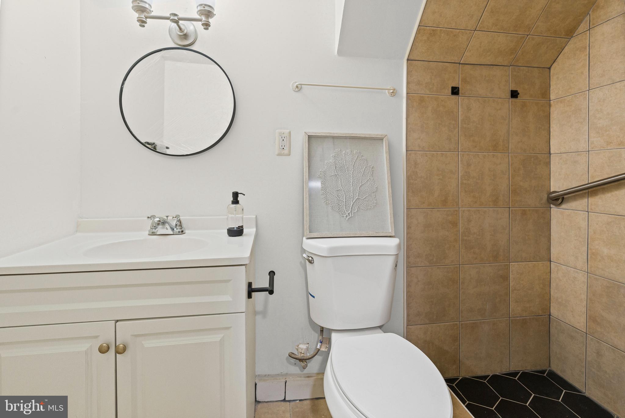 1135 Myrtle Avenue Baltimore, MD 21201 - Photo 6 of 31 a bathroom with a toilet sink vanity and shower