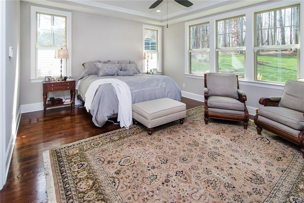 210 Patternote Road, Unit 31 Mooresville, NC 28117 - Photo 10 of 29 a spacious bedroom with a bed a couch and a large window with wooden floor